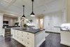 Modern home with Kitchen, Range Hood, Microwave, Refrigerator, Wine Cooler, Granite Counter, Ice Maker, Wall Lighting, Ceiling Lighting, Drop In Sink, Medium Hardwood Floor, Dishwasher, White Cabinet, and Stone Counter. The gourmet kitchen is heart of the home, styled with six double hung windows overlooking the bay. Crafted with Dutch Made cabinetry, matrix leather granite countertops and three sinks, its collection of top-of-the-line appliances includes four Fisher and Paykel DishDrawers. A walk-in food pantry, separate butler’s pantry and wine closet are an entertainer’s dream.
Photo 5 of Coastal Comfort and New England Elegance Siesta Key Bayfront Mansion