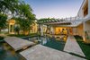 Modern home with Outdoor, Large Patio, Porch, Deck, Garden, Grass, Large Pools, Tubs, Shower, Landscape Lighting, Hanging Lighting, Back Yard, Post Lighting, Swimming Pools, Tubs, Shower, Flowers, Trees, Walkways, Gardens, Field, Shrubs, Infinity Pools, Tubs, Shower, Side Yard, and Lap Pools, Tubs, Shower. Revered architect Jerry Sparkman transformed a once-modest home into a modern masterpiece, blending innovative design with the natural Florida landscape. Located at 1212 Westway Drive, the residence is marketed exclusively by Joel Schemmel of Premier Sotheby’s International Realty’s Sarasota – Downtown office. Photo of STRANDHUS, A MODERN LIDO SHORES ESTATE