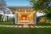 Modern home with Outdoor, Side Yard, Grass, Shrubs, and Trees. A second renovation of the home was completed in 2018, following the purchase of the adjacent lot. A lux urious master wing was built, connected to the main house by a breathtaking glass hallway. The new wing boasts an expansive master suite and a stunning office. Sliding glass doors open to a private garden and spa. Photo 4 of STRANDHUS, A MODERN LIDO SHORES ESTATE