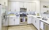 Modern home with Kitchen, White Cabinet, Dishwasher, Wall Oven, Refrigerator, Cooktops, Engineered Quartz Counter, Microwave, Light Hardwood Floor, Ceramic Tile Backsplashe, and Undermount Sink. Kitchens boast crisp, white quartz countertops and modern stainless-steel appliances. Photo 8 of The Enclave
