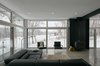 Modern home with Living Room, Lamps, Concrete Floor, Chair, Recessed Lighting, Sectional, Wood Burning Fireplace, Floor Lighting, and Rug Floor. The main level living space of Industrial Farmhouse by Christopher Simmond Architect Inc. is a transparent social hub for viewing the rural landscape. The house is situated to optimize views, as well as protect occupants from the blazing summer sun and stiff winter winds. Photo 2 of Industrial Farmhouse