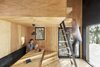 Modern home with Dining Room and Table. The bed is suspended by steel rods over the dinning table and is accessible by a ladder. Photo 4 of La Pointe by L'Abri