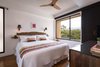 Modern home with Bedroom, Accent Lighting, Wall Lighting, Bench, Dresser, Laminate Floor, Bed, Medium Hardwood Floor, Floor Lighting, and Shelves. Guest King Bedroom Photo 2 of Maui Modern, Budget-Luxury Remodeled Vacation Rental