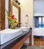 Modern home with Bath Room, Wall Lighting, Granite Counter, Open Shower, Vessel Sink, Concrete Wall, Full Shower, One Piece Toilet, Soaking Tub, and Ceramic Tile Floor. Custom vanity with vintage Hawai'ian mirrors bring together the old and the new. Photo 10 of Maui Modern, Budget-Luxury Remodeled Vacation Rental