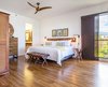 Modern home with Bedroom, Accent Lighting, Night Stands, Storage, Dresser, Medium Hardwood Floor, Bench, Bed, Laminate Floor, and Wall Lighting. Master bedroom with antique Balinese headboard. Photo 11 of Maui Modern, Budget-Luxury Remodeled Vacation Rental