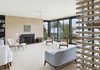 Modern home with Living Room, End Tables, Wood Burning Fireplace, Ceiling Lighting, Chair, Medium Hardwood Floor, Bookcase, Sofa, and Ottomans. Living room Photo 4 of Bay of Fundy house