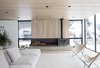 Modern home with Living Room, Sectional, Light Hardwood Floor, Chair, Ceiling Lighting, and Wood Burning Fireplace. Wood burning stove on concrete plinth in living room Photo 3 of Gilbert House
