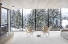 Modern home with Living Room, Light Hardwood Floor, Wood Burning Fireplace, and Chair. Framed snowy views from upper floor to ski hills beyond through wall to wall full height windows Photo 5 of Gilbert House