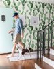 Modern home with Hallway and Medium Hardwood Floor. Cactus wallpaper greets guests in the entry way and compliments the sea foam-colored front door. Photo of Modern Spanish Revival