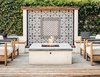 Modern home with Outdoor, Retaining Fences, Wall, Back Yard, Wood Patio, Porch, Deck, and Shrubs. A cement-tiled fountain wall serves as the backdrop for an outdoor fire pit and the family's post-work gathering spot. Photo 6 of Modern Spanish Revival