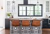 Modern home with Kitchen, White Cabinet, Colorful Cabinet, Range, Pendant Lighting, Drop In Sink, Dishwasher, Ceramic Tile Backsplashe, Range Hood, Recessed Lighting, Marble Counter, Medium Hardwood Floor, Wood Counter, and Microwave. Graphic pattered tile is used throughout the house in small doses, to add a touch of whimsy to more classic black and white elements. Photo 8 of Modern Spanish Revival