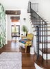 Modern home with Hallway and Medium Hardwood Floor. We painted the original iron staircase and added wooded beams throughout the house to balance modern pops of color with older elements, in order to not have the house feel "too new". Photo 10 of Modern Spanish Revival