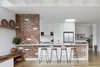 Modern home with Kitchen, Engineered Quartz Counter, Track Lighting, Cooktops, Refrigerator, Ceramic Tile Backsplashe, Light Hardwood Floor, Subway Tile Backsplashe, and White Cabinet. Existing brick wall is reinstated with recycled brick and opened to form connection between kitchen and living Photo 5 of Preston 1