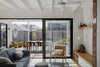 Modern home with Living Room, Storage, Chair, Bench, Shelves, Ceiling Lighting, Light Hardwood Floor, Accent Lighting, Rug Floor, and Pendant Lighting. Expressed ceiling beams and wide sliding doors extend the living space to the exterior. Photo 13 of Preston 1