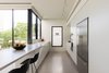 Modern home with Kitchen, Engineered Quartz Counter, Wall Oven, Undermount Sink, Refrigerator, Limestone Floor, Microwave, and White Cabinet. Looking at kitchen Photo 5 of Harimon House