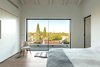Modern home with Bedroom, Bed, Medium Hardwood Floor, Chair, and Wardrobe. Bright master bedroom, frames view Photo 10 of Harimon House