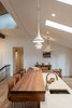 Modern home with Dining Room, Pendant Lighting, Recessed Lighting, Bar, Medium Hardwood Floor, and Stools. The island with a walnut butcher block bar top was designed to make it easy to socialize while preparing a meal for guests. Photo 4 of Bellevue Home Remodel