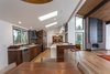 Modern home with Kitchen, Dishwasher, Engineered Quartz Counter, Wall Oven, Range Hood, Refrigerator, Pendant Lighting, Cooktops, Recessed Lighting, Undermount Sink, Ceiling Lighting, Wall Lighting, Microwave, Beverage Center, Wood Cabinet, Subway Tile Backsplashe, Ceramic Tile Backsplashe, Medium Hardwood Floor, and Accent Lighting. Previously divided by walls, the kitchen, dining and living spaces are now fully connected. Photo 3 of Bellevue Home Remodel