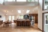 Modern home with Dining Room, Medium Hardwood Floor, Shelves, Stools, Table, Bar, Pendant Lighting, and Chair. Removing the wall lets light from the clerestory windows reach the north facing kitchen and dining room. Two new skylights over the work island were also added. Photo 7 of Bellevue Home Remodel