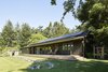 Modern home with Exterior, Metal Roof Material, Wood Siding Material, Cabin Building Type, and Gable RoofLine. Long Cabin south deck and fire pit with existing stone retaining wall. Photo 4 of Island Cabins