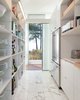 Modern home with Kitchen, Medium Hardwood Floor, White Cabinet, and Marble Counter. View into the open pantry that hides away the clutter from the open kitchen. Photo 12 of North Beach Residence