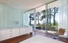 Modern home with Medium Hardwood Floor, Chair, and Recessed Lighting. View into the master bedroom and vanity, floor to ceiling windows allow full views to the water front. Photo 16 of North Beach Residence