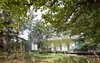 Modern home with Exterior, Flat RoofLine, Beach House Building Type, Green Roof Material, House Building Type, Glass Siding Material, Metal Siding Material, and Cabin Building Type. Outdoor view of the wooded area surrounding the home. Photo 17 of North Beach Residence