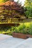 Modern home with Outdoor, Back Yard, Walkways, Large Patio, Porch, Deck, Wood Patio, Porch, Deck, Gardens, Trees, Raised Planters, Flowers, Shrubs, Metal Fences, Wall, Grass, and Concrete Patio, Porch, Deck. Landscape Design by Land Morphology Photo 5 of Magnolia Residence