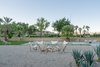 Modern home with Outdoor, Large Patio, Porch, Deck, Back Yard, Raised Planters, Shrubs, Trees, Large Pools, Tubs, Shower, Stone Patio, Porch, Deck, Hardscapes, Horizontal Fences, Wall, and Concrete Patio, Porch, Deck. The stone-edged fire pit is a family favorite. "We do s'mores around the fire every time we go, walk the golf course at night, and love watching the sunsets against the pink mountains," she says. Photo 3 of Borrego Springs Midcentury