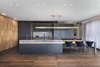 Modern home with Kitchen, Marble Counter, Pendant Lighting, Medium Hardwood Floor, Wood Cabinet, and Colorful Cabinet. The integral kitchen unit is a combination of woods with different finishes surrounded on all sides by perforated brass designed to provide a floating, folding look, turning into the work area located behind the unit. Photo 2 of The Layers apartment