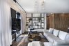 Modern home with Living Room, Ceiling Lighting, Lamps, Coffee Tables, Shelves, and Medium Hardwood Floor. Another element creating a series of links between the spaces is a carpentry element with a linear graphic texture in three dimensions, created using layers of carefully designed wooden strips. They combine to form a functional surround, concealing storage units within and doors at both ends. Photo 8 of The Layers apartment