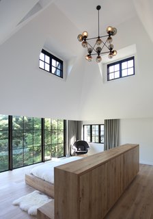 The high-ceilinged master bedroom of Sterling Ridge enjoys unobstructed views of the surrounding forest.