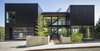 Modern home with Exterior, Wood Siding Material, House Building Type, Flat RoofLine, and Green Roof Material. The U-shaped plan of Music Box Residence by Scott Edwards Architecture has large volumes on both sides with a glassy two-story entry space in the middle. A long bridge, with a bamboo forest below, leads from the sidewalk to the main entry. The exterior is clad in black stained siding reminiscent of sho-sugi ban in order to pay homage to the family's Japanese ancestry. Photo of Music Box Residence
