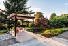 Modern home with Outdoor, Back Yard, Wood Patio, Porch, Deck, and Gardens. An arbor-covered deck looks out over an oval rain garden planted with a mix of flowering native plants. Photo 3 of Magnolia Modern