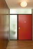 Modern home with Hallway. A view of the entry from inside. A mid-century palette and simple modern graphic of warm walnut, textured glass, painted door, and stained wood door jambs. Photo 5 of Los Feliz Residence