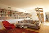 Modern home with Living Room, Ceiling Lighting, Chair, Coffee Tables, Rug Floor, and Sofa. The lower floor has been turned into a den, where formerly it had been more divided up. A long bookcase of vinyl records and books frames the room. Photo 9 of Los Feliz Residence
