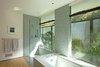 Modern home with Ceiling Lighting. The master bathroom opens up to a private garden and ample light. A ‘wet-zone’ is denoted by mosaic marble. Photo 11 of Los Feliz Residence