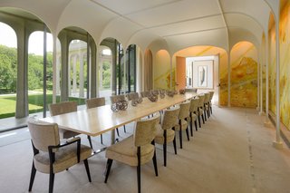 The dining room, reminiscent of the Glass House at New Canaan, features the work of Matthew Ritchey.