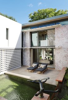 Gallagher Lourens Architects revamped 68 Jonkershoek's inner courtyard with a natural pool, a wooden deck, and a brickwork brise soleil.