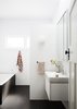 Modern home with Bath Room, Ceramic Tile Wall, Ceiling Lighting, Porcelain Tile Floor, Enclosed Shower, Wall Mount Sink, Wall Lighting, Drop In Tub, and One Piece Toilet. Bathroom Photo 10 of Coburg House