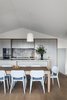 Modern home with Kitchen, Colorful Cabinet, Range Hood, Wall Oven, Quartzite Counter, Cooktops, Wood Cabinet, Undermount Sink, Refrigerator, Light Hardwood Floor, Pendant Lighting, Dishwasher, and Stone Slab Backsplashe. Kitchen & Meals area Photo 4 of Yeronga House
