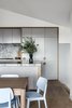 Modern home with Kitchen, Colorful Cabinet, Undermount Sink, Refrigerator, Wood Cabinet, Wall Oven, Dishwasher, Range Hood, Quartzite Counter, Light Hardwood Floor, Stone Slab Backsplashe, and Cooktops. Kitchen detail Photo 9 of Yeronga House