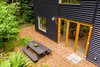 Modern home with Outdoor, Grass, Woodland, Front Yard, Raised Planters, Field, and Trees. Large folding doors open the home to the private yard, raised bed gardens and picnic area. Photo 3 of Guemes Island Home
