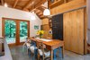 Modern home with Dining Room, Chair, Storage, Ceiling Lighting, Pendant Lighting, Concrete Floor, and Table. The long kitchen table, which can comfortably sit eight, has been handcrafted from salvaged cedar. Birch and chalkboard barn doors effortlessly hide any unwanted clutter. Photo 7 of Guemes Island Home