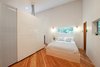 Modern home with Ceiling Lighting and Storage. In the main bedroom, fir floors and simple fixtures add to the minimal design. Custom-set windows thoughtfully frame the nearby forest. Photo 15 of Guemes Island Home