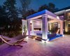 Modern home with Outdoor, Back Yard, Large Pools, Tubs, Shower, Trees, Swimming Pools, Tubs, Shower, and Large Patio, Porch, Deck. As day turns to night, the outdoor pavilion area turns itself into a hot spot for nighttime activities. Whether you are entertaining guests or unwinding in the spa with an end of day drink, the linear fire feature and Pal LED lights illuminate and make this scene come alive. Photo 2 of Modern Tranquility