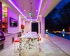 Modern home with Outdoor, Hanging Lighting, Large Patio, Porch, Deck, Large Pools, Tubs, Shower, Swimming Pools, Tubs, Shower, and Back Yard. Bringing an effortless, resort vibe, this outdoor kitchen pavilion welcomes conversation and conviviality. Stainless steel appliances are expertly grouped at tile clad counters adjacent to modern island bar seating creating the perfect spot for outdoor dining and entertaining with an all-encompassing view of the entire outdoor space. Photo 3 of Modern Tranquility