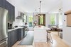 Modern home with Kitchen, Colorful Cabinet, Marble Counter, and Light Hardwood Floor. The spacious gourmet kitchen features Bertazzoni appliances and a white marble top island with built-in wine fridge. Photo 5 of A Bedford-Stuyvesant home that celebrates lifestyle