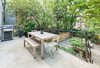 An approximately 200 sq. ft. deck overlooks a well-landscaped backyard featuring bluestone pavers and vibrant plant life. Photo 12 of A Bedford-Stuyvesant home that celebrates lifestyle modern home