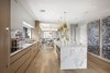 Modern home with Kitchen, Pendant Lighting, Marble Counter, Cooktops, Marble Backsplashe, Range Hood, Refrigerator, and Wood Cabinet. Prep gourmet meals with ease in a custom kitchen with large center island, marble countertops and backsplash, and top-of-the-line stainless steel appliances (Miele and Sub-Zero). Photo 3 of A Brooklyn Penthouse With Three Terraces